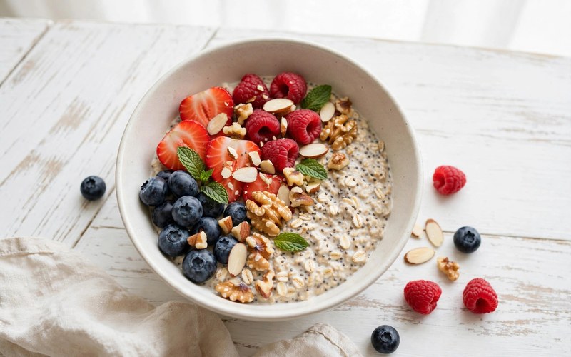 Overnight oats breakfast bowl with berries and nuts in morning light